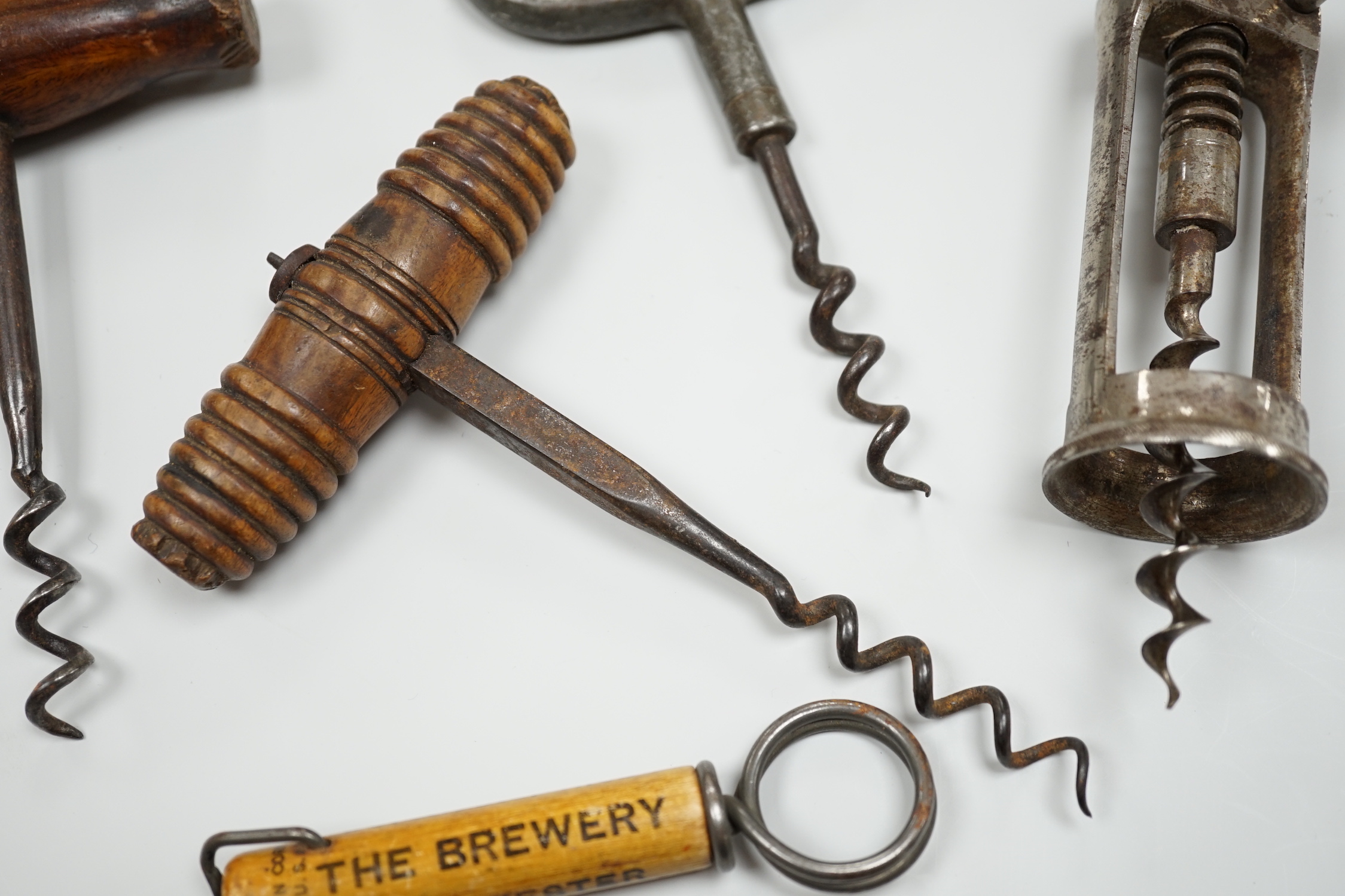 A 19th century iron corkscrew, with a turned wood handle and four other corkscrews (5)